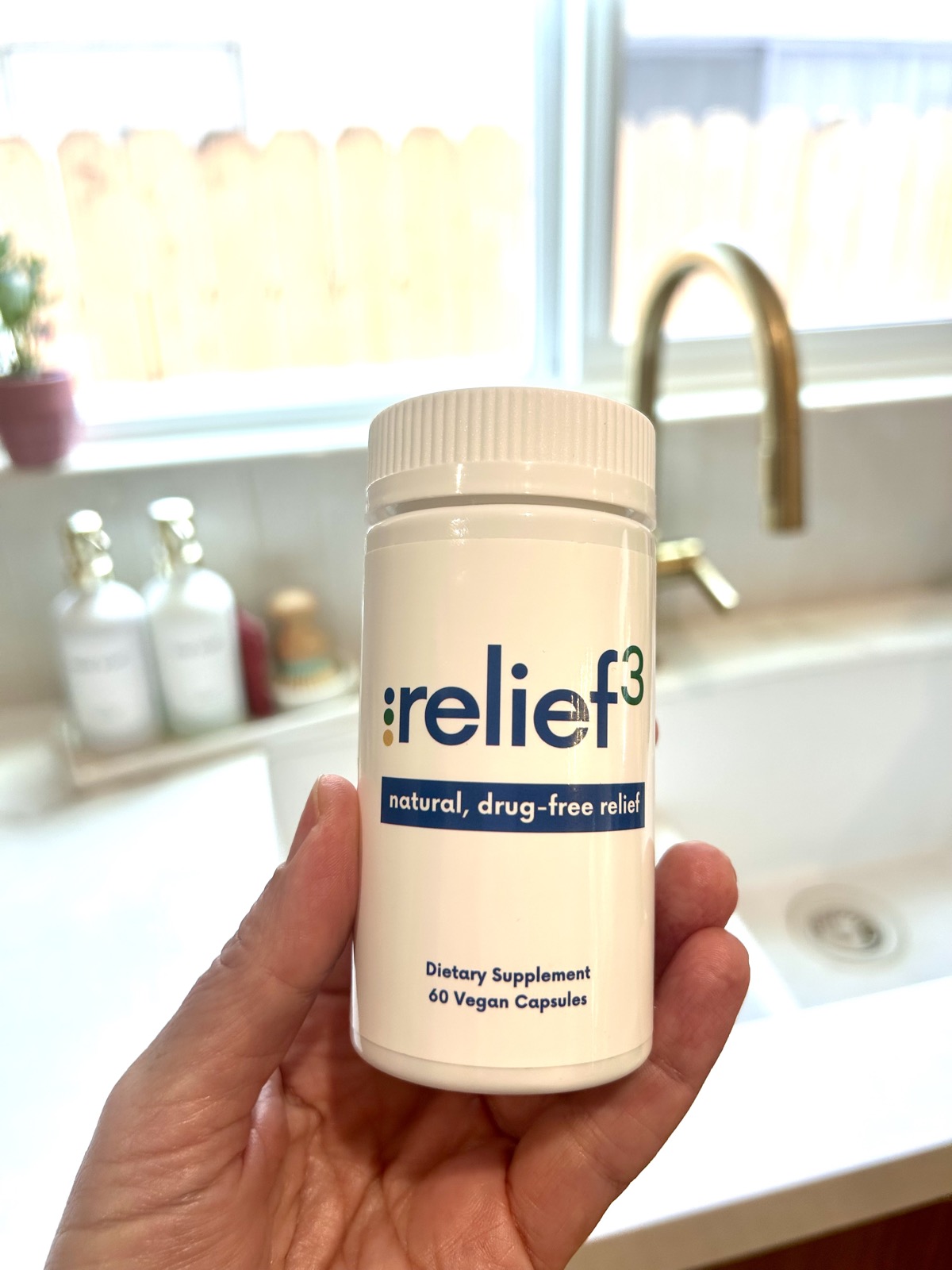Relief3 supplement bottle held in hand for joint pain relief