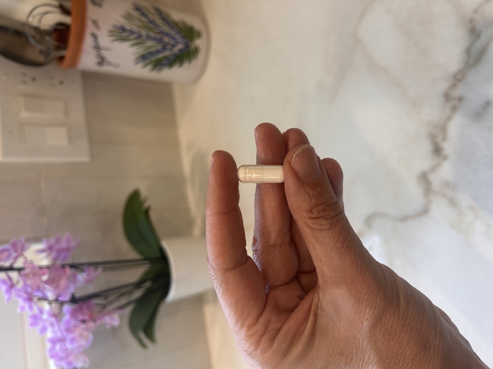 Close-up of hand holding a Relief3 capsule for joint pain relief